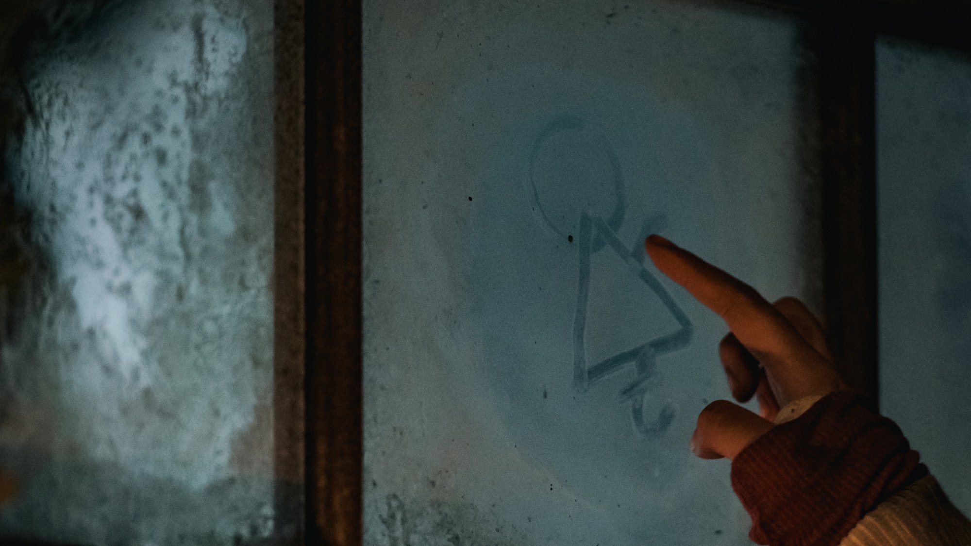 La main d'une fille a dessiné un symbole étrange dans une fenêtre de cabine brumeuse.