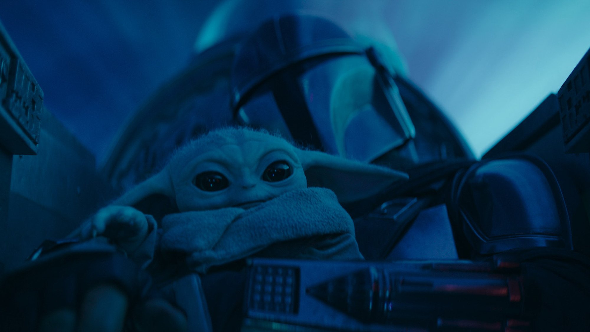 Un petit extraterrestre vert avec de grandes oreilles et de grands yeux est assis dans un cockpit avec un guerrier de science-fiction portant un casque.