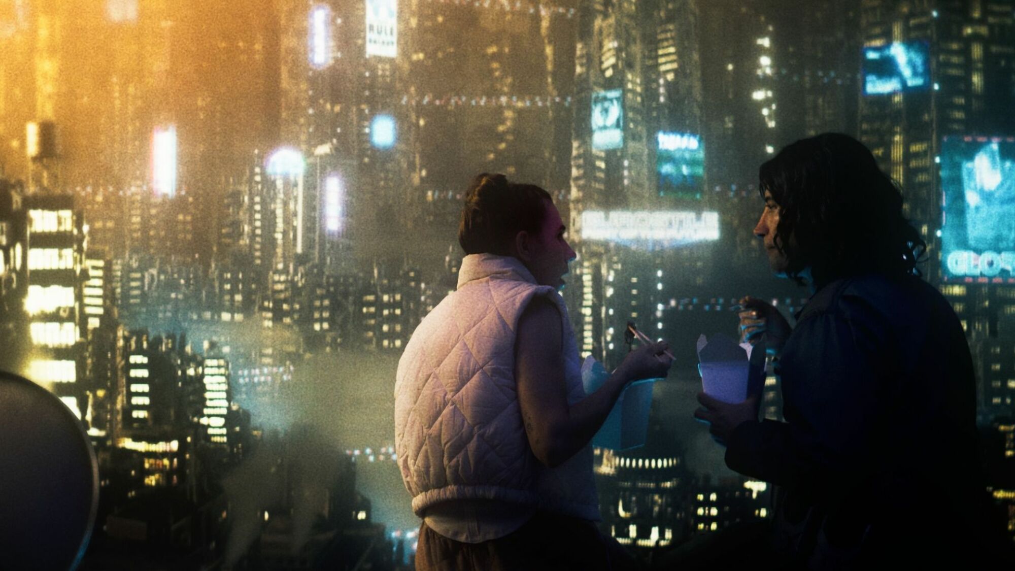 Le film MOLLI ET MAX DANS LE FUTUR présente toujours un couple assis contre un paysage urbain futuriste.