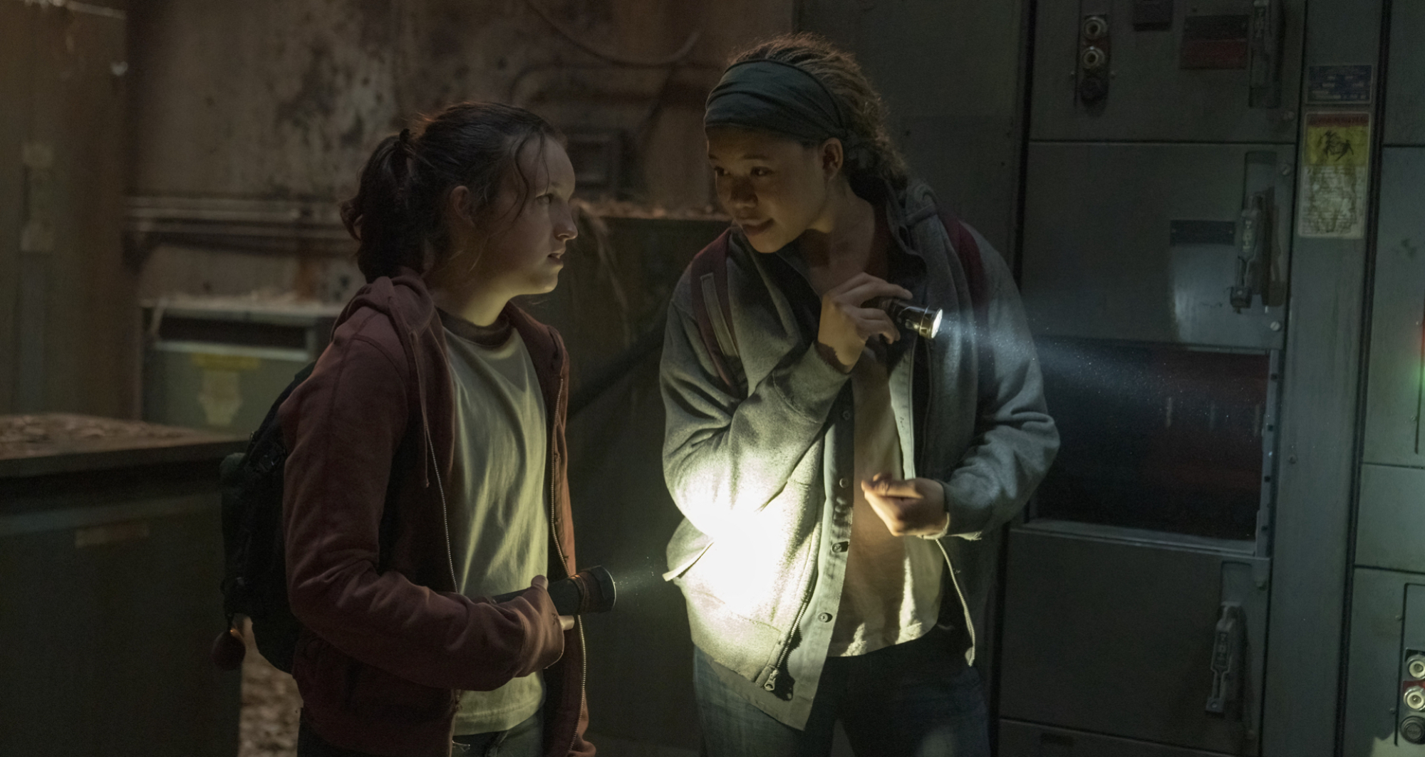 Deux adolescentes se tiennent dans un bâtiment abandonné avec des torches.