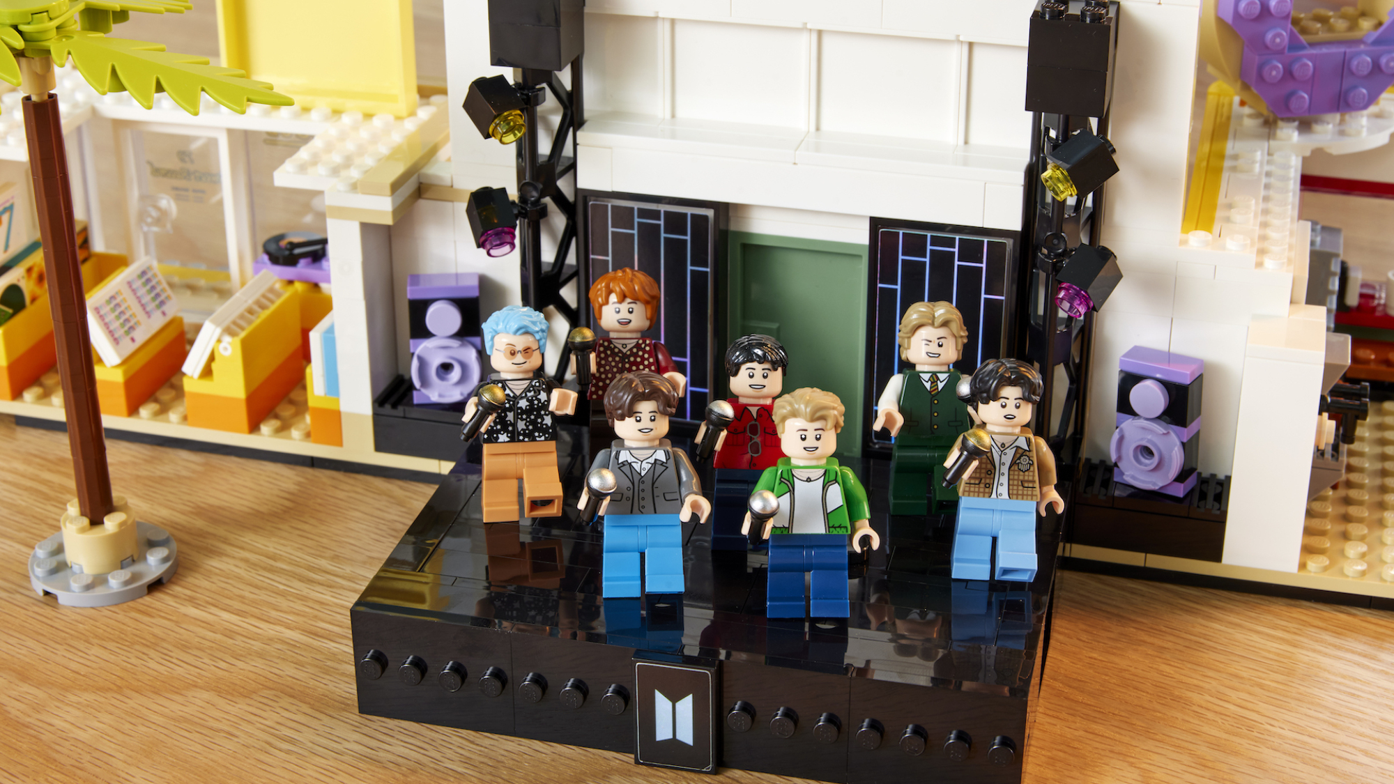BTS en tant que figurines Lego debout sur une scène Lego. 