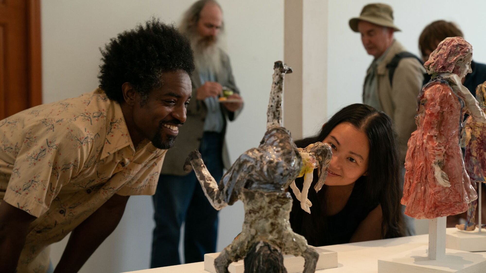 André Benjamin et Hong Chau observent des sculptures d'argile dans 