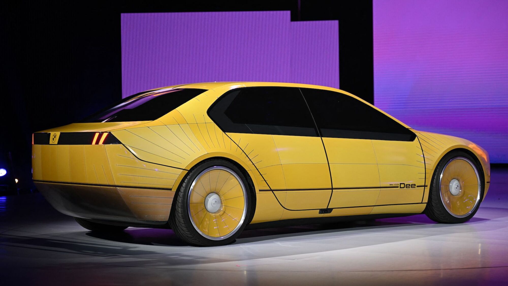 Une voiture jaune est assise sur scène lors d'une conférence technique.