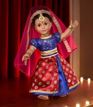La poupée Kavi est vêtue d'une robe indienne traditionnelle aux couleurs vives et exécute une danse sur une scène éclairée. 