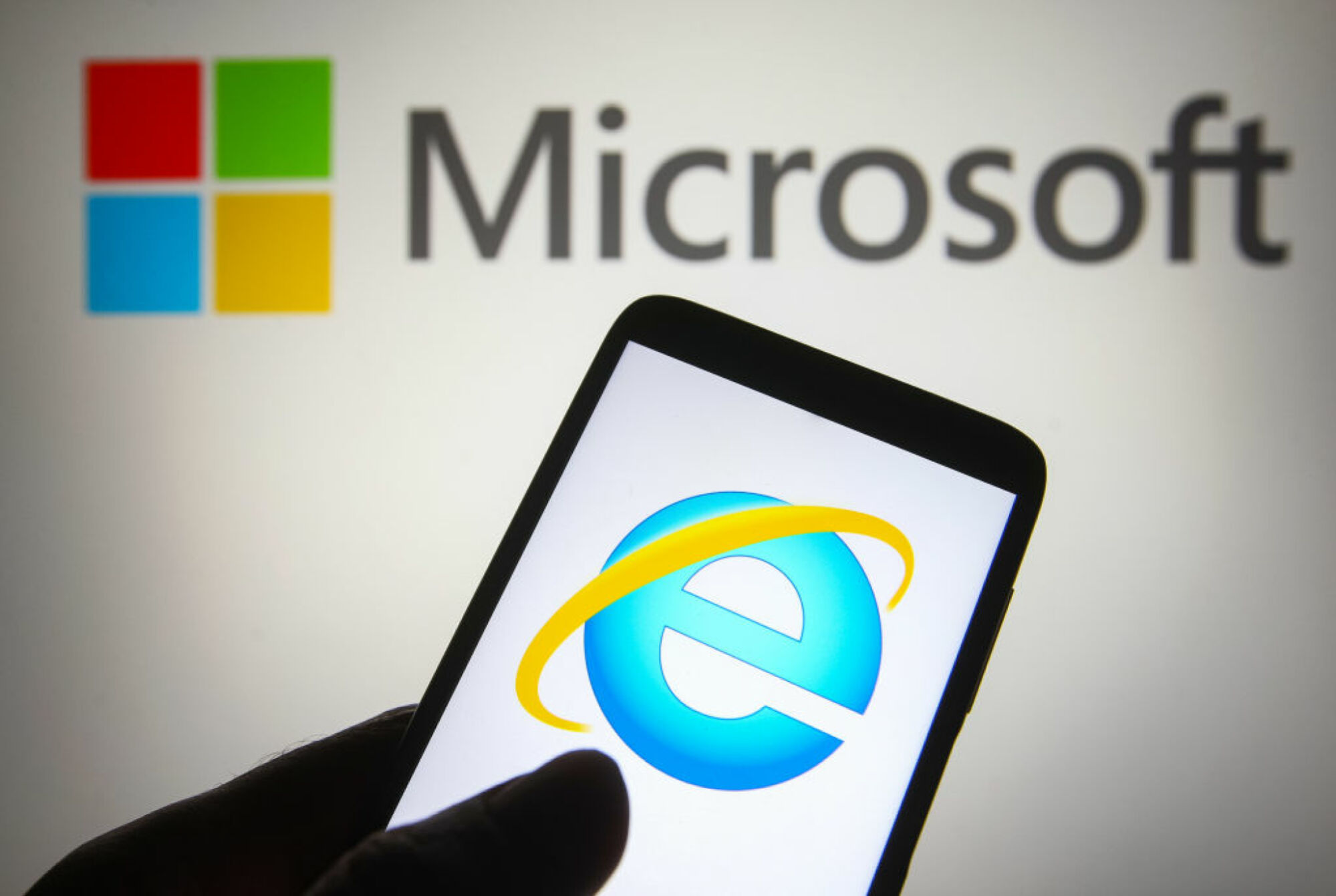 Internet Explorer sur un smartphone avec le logo Microsoft en arrière-plan