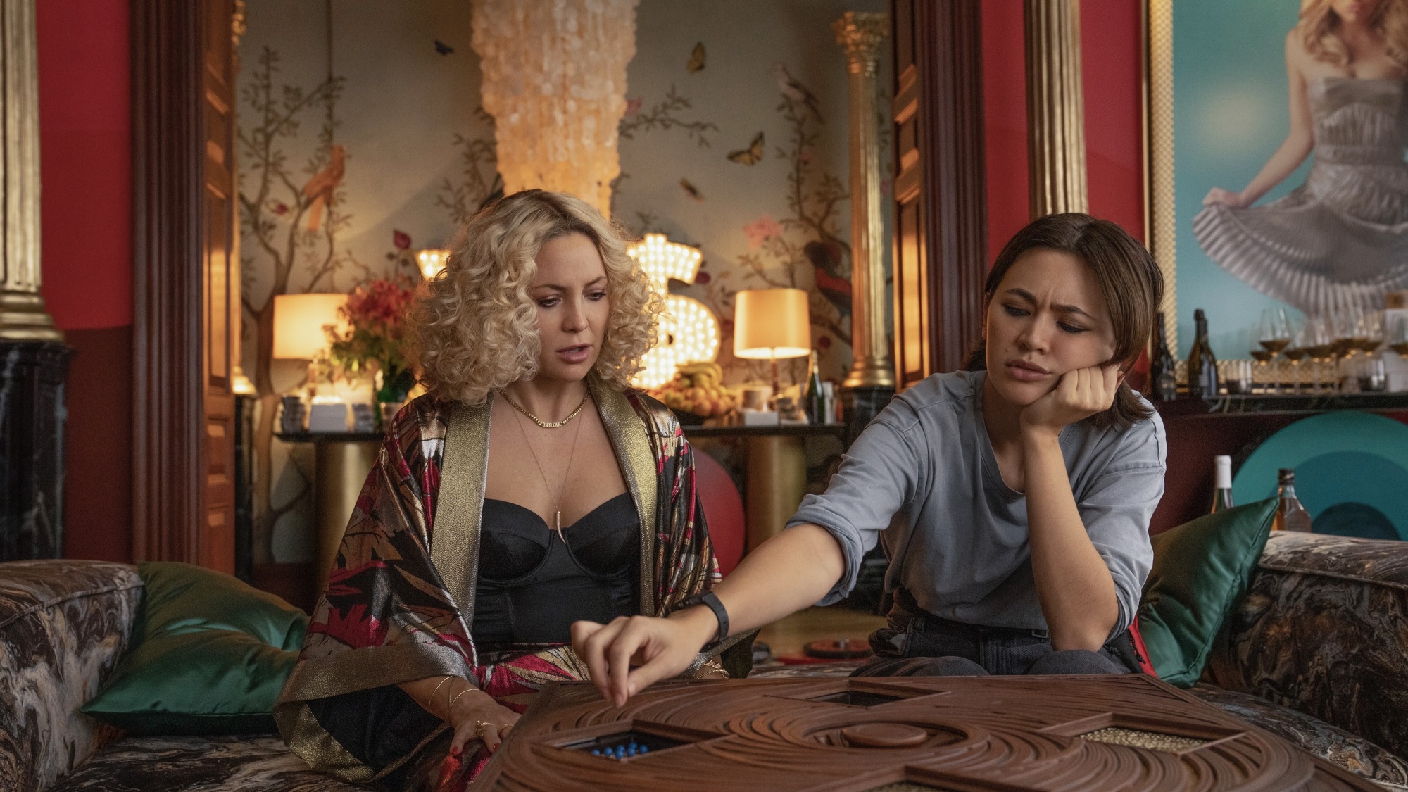 Deux femmes travaillent sur un puzzle dans un salon richement décoré.