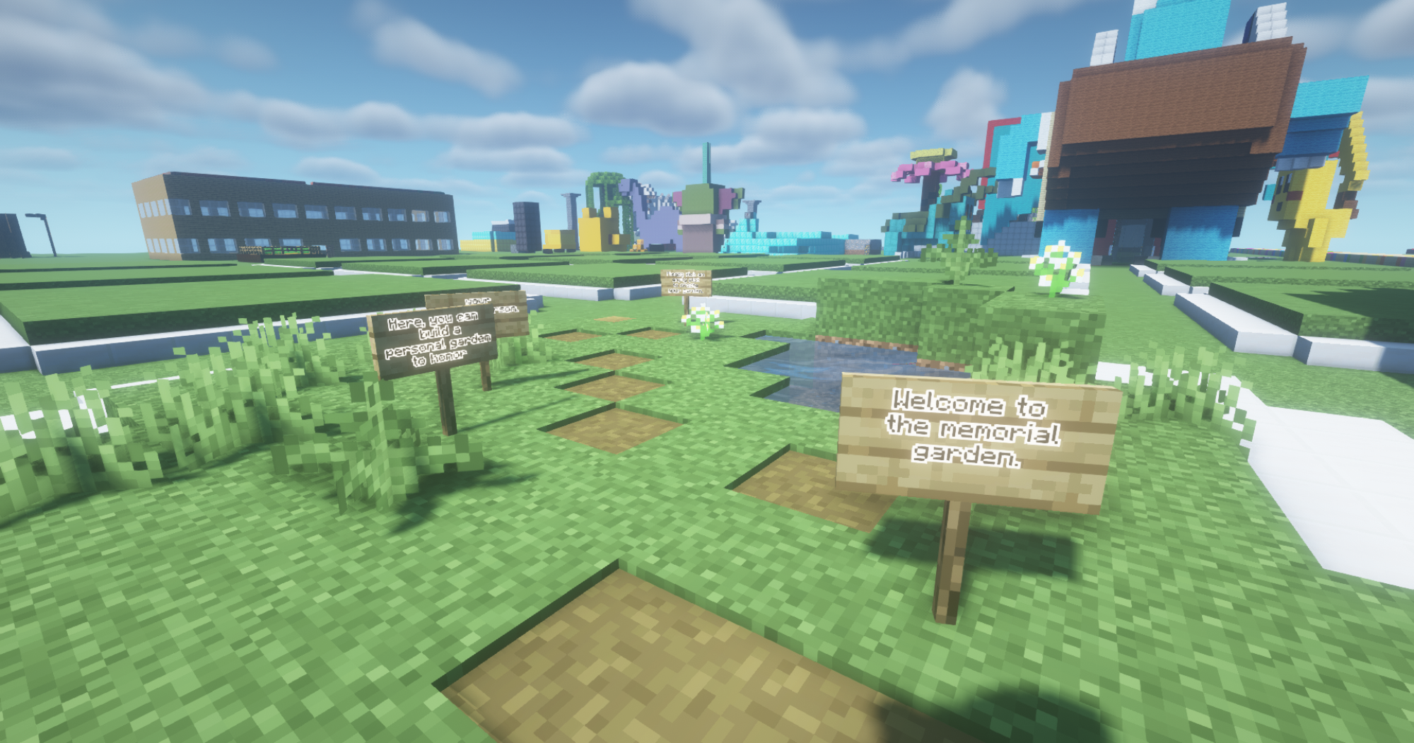 Une zone herbeuse avec des panneaux et des bâtiments dans le jardin commémoratif d'ExperienceCraft. 
