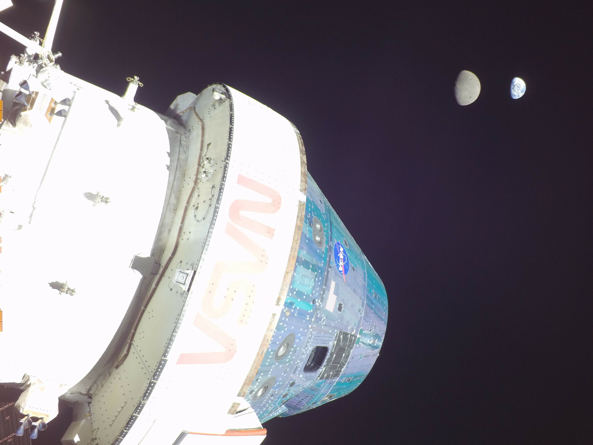 le vaisseau spatial Orion avec la lune et la terre au loin