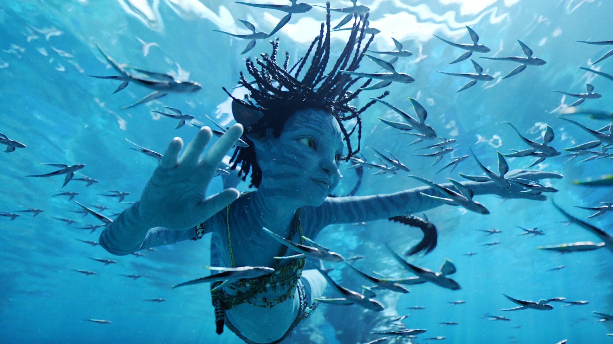 un enfant Na'vi nage dans "Avatar : la voie de l'Eau."