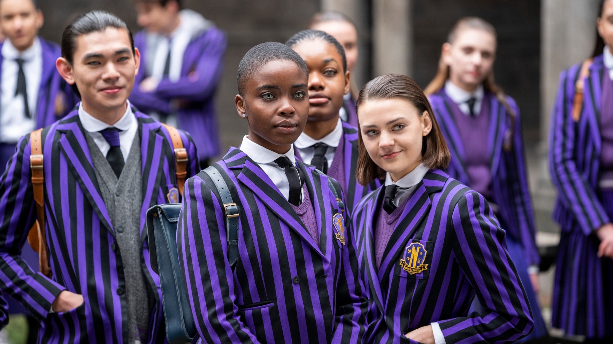 Un groupe d'étudiants en uniforme rayé violet et noir.