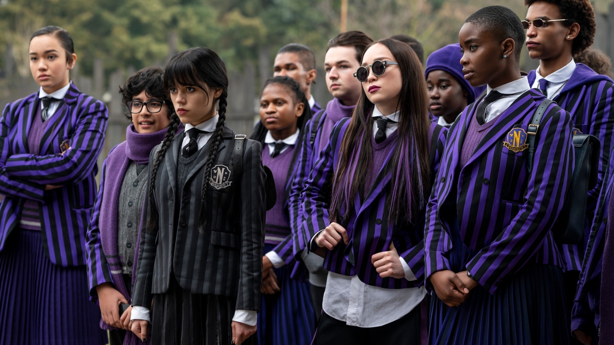 Un groupe d'étudiants portant des uniformes rayés se tiennent ensemble. 