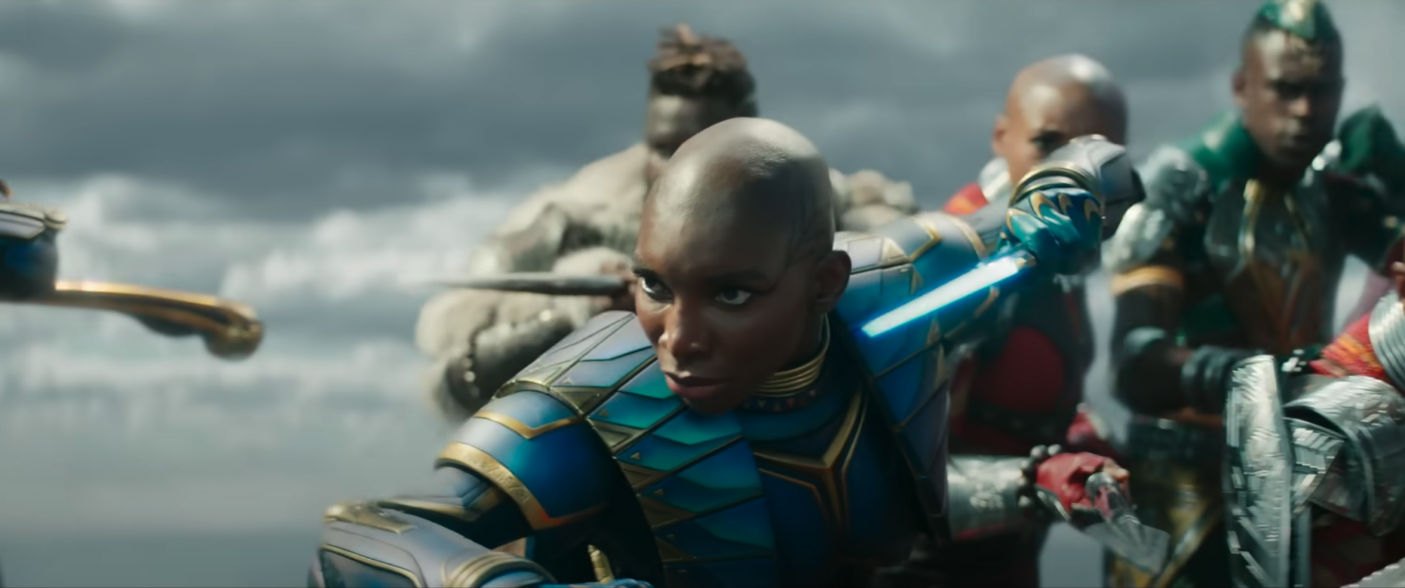 Michaela Coel dans le rôle d'Aneka dans le costume des Midnight Angels, une femme noire au crâne rasé portant une armure bleu vif.