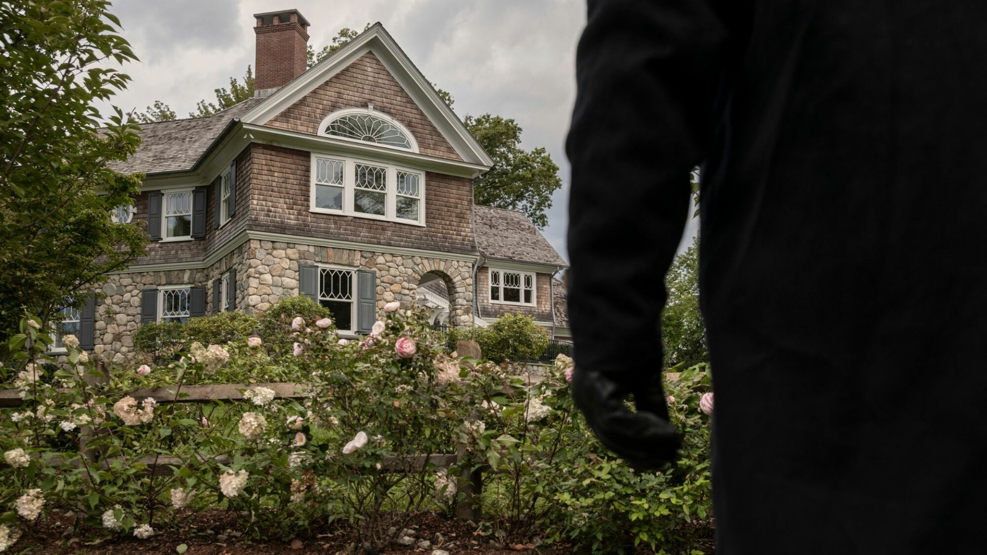 Une silhouette sombre se cache autour d'une maison victorienne. 