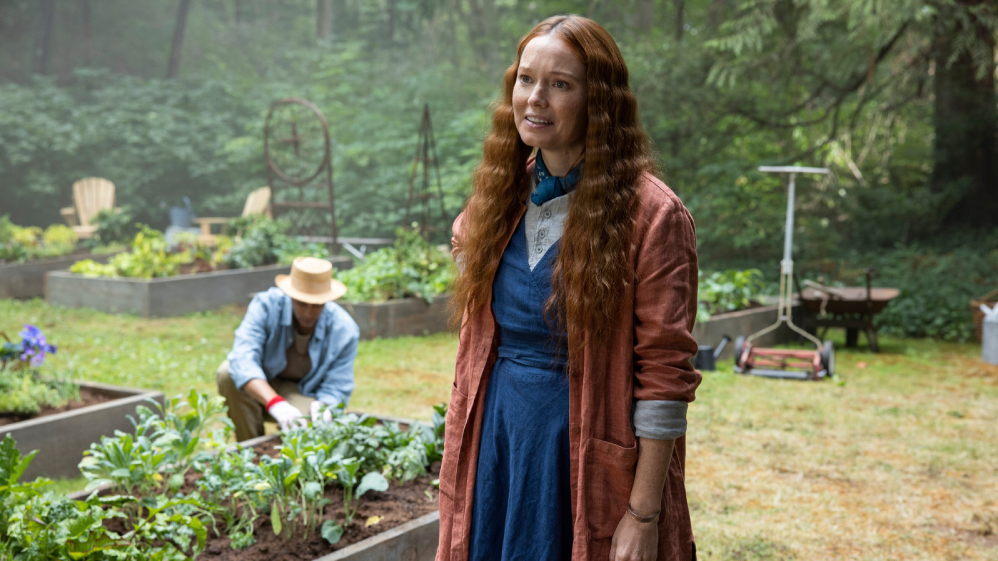 Les femmes aux cheveux orange se tiennent dans un jardin. 