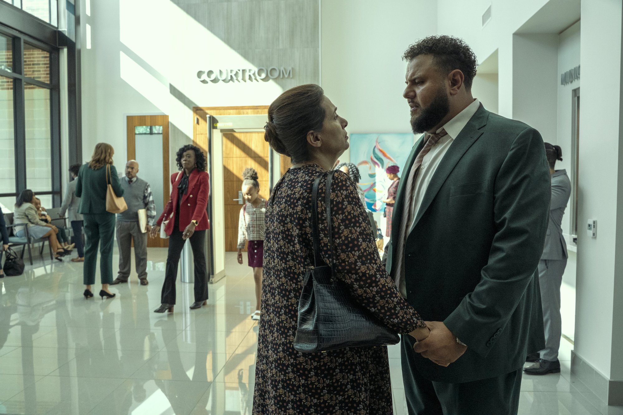 Farah Bsieso et Mo Amer attendent devant une salle d'audience à 'Mo'.