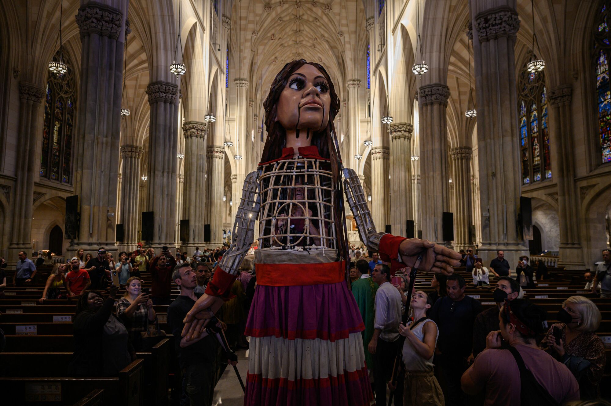 Amal se tient au milieu d'une foule de paroissiens à la cathédrale Saint-Patrick. 