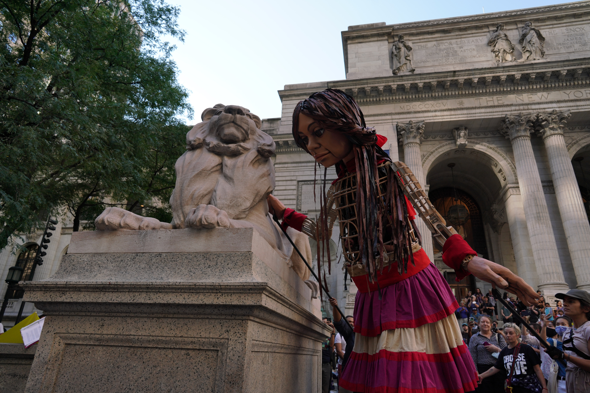 Amal se penche sur l'un des lions de pierre qui repose à l'extérieur de la bibliothèque publique de New York. 