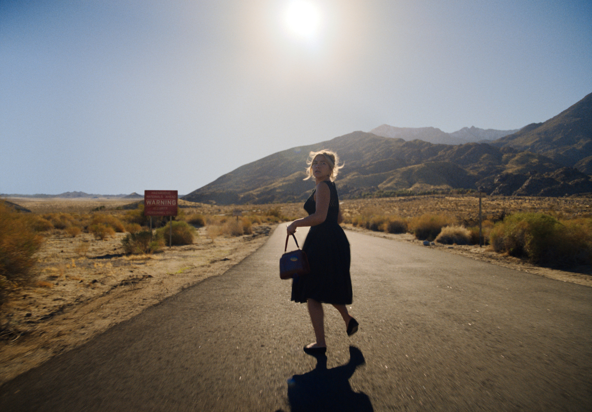 Florence Pugh descend une route déserte dans "Ne t'inquiète pas chérie."