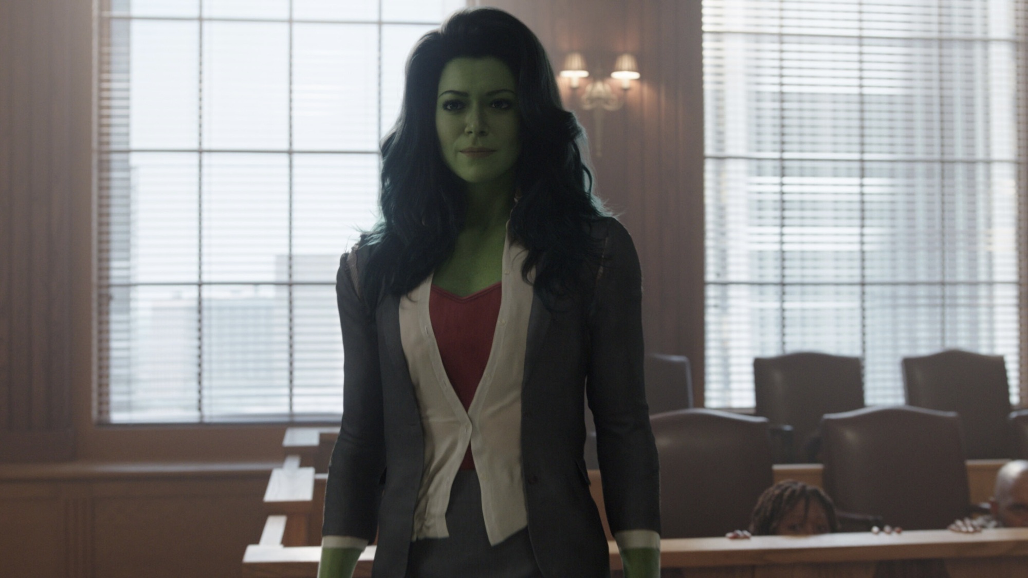 She-Hulk dans un costume d'affaires debout dans une salle d'audience.