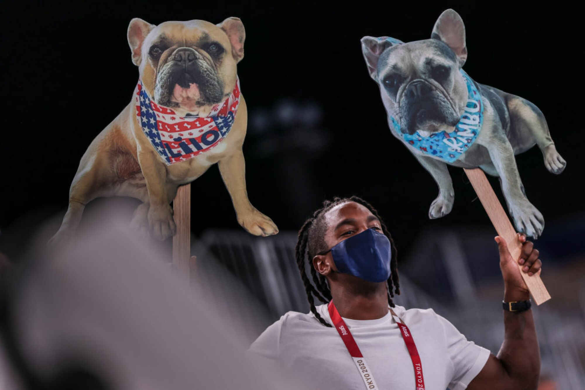 Image d'un fan tenant des photos découpées des chiens de Simone Biles