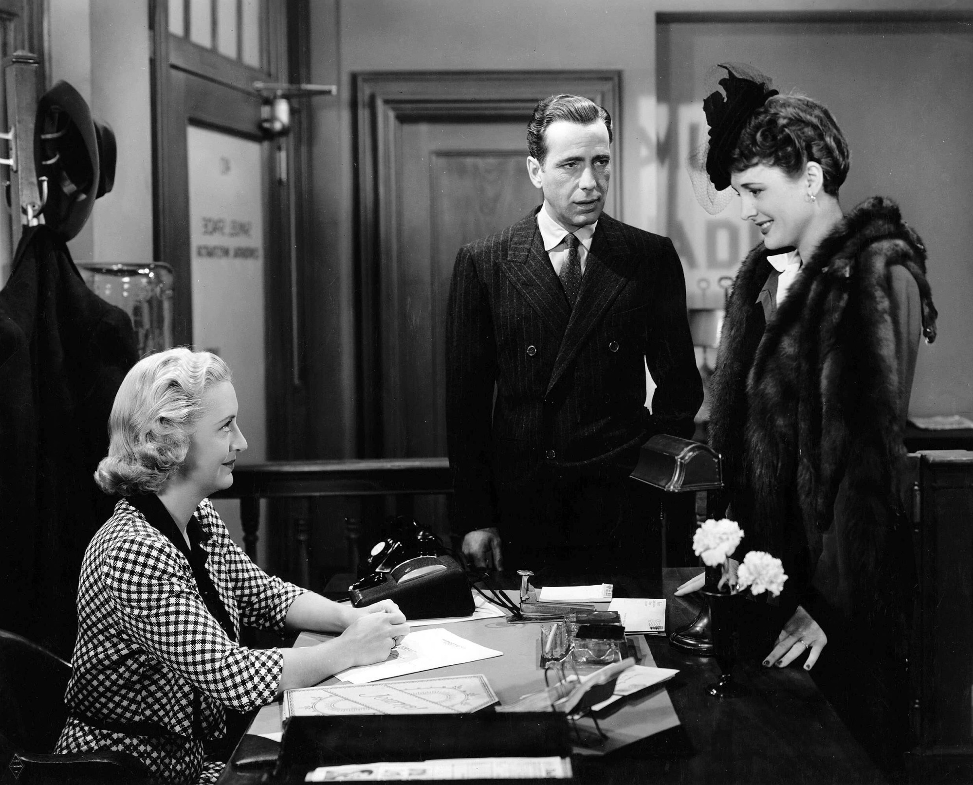 Humphrey Bogart, Mary Astor et Lee Patrick discutent dans un bureau de 