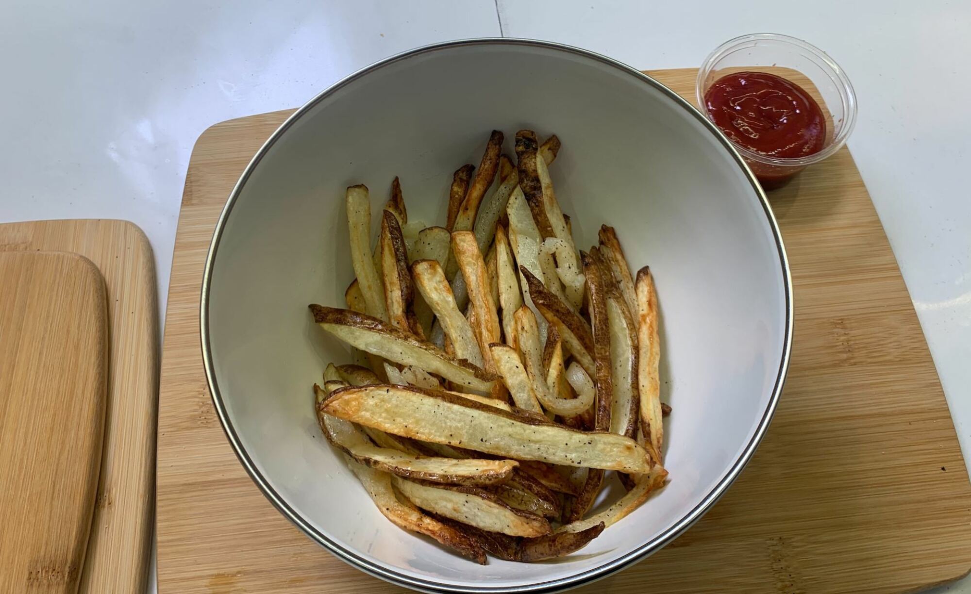 frites cuites dans un bol avec du ketchup sur le côté