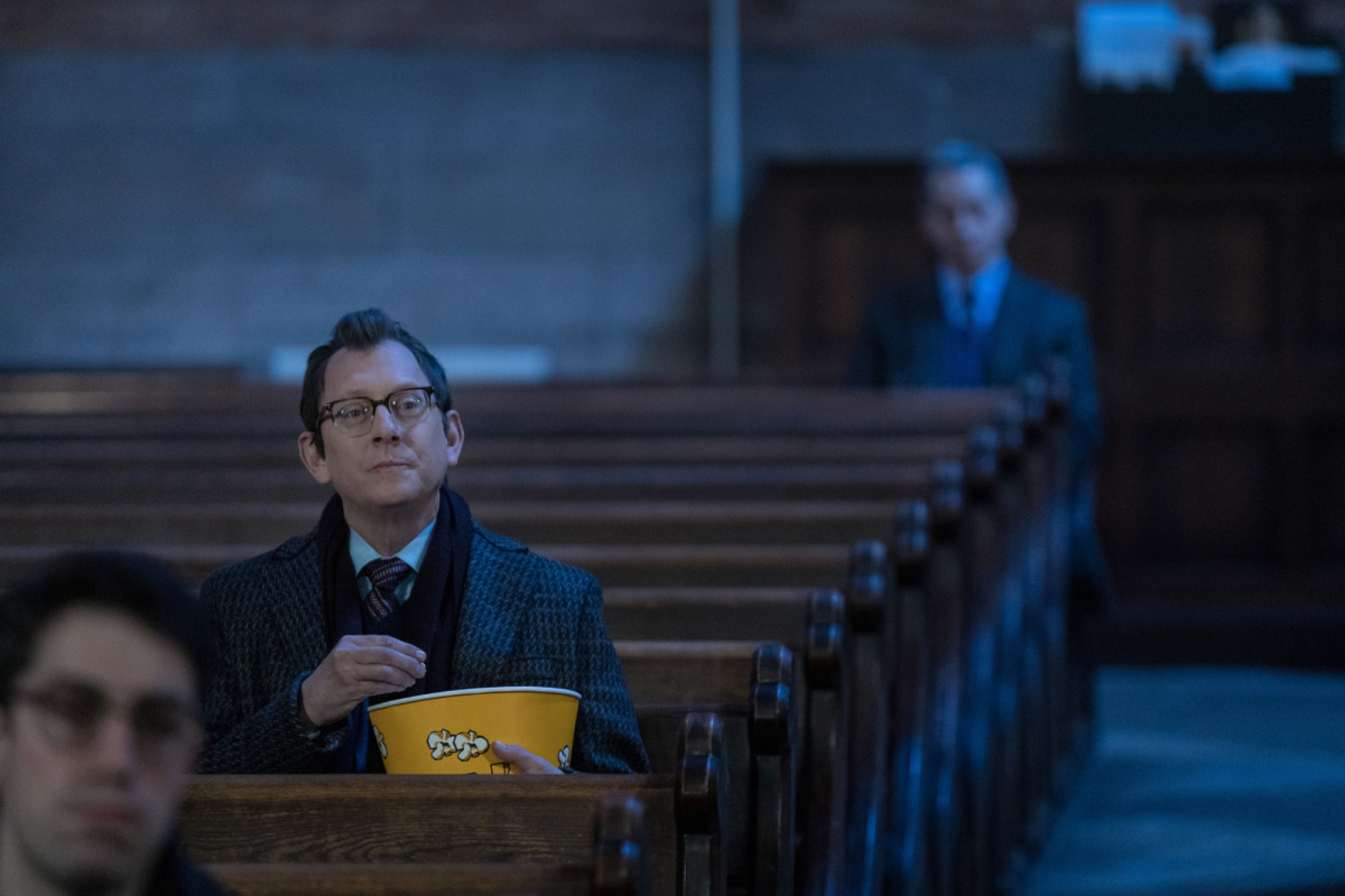 Michael Emerson mangeant du pop-corn dans une église. 