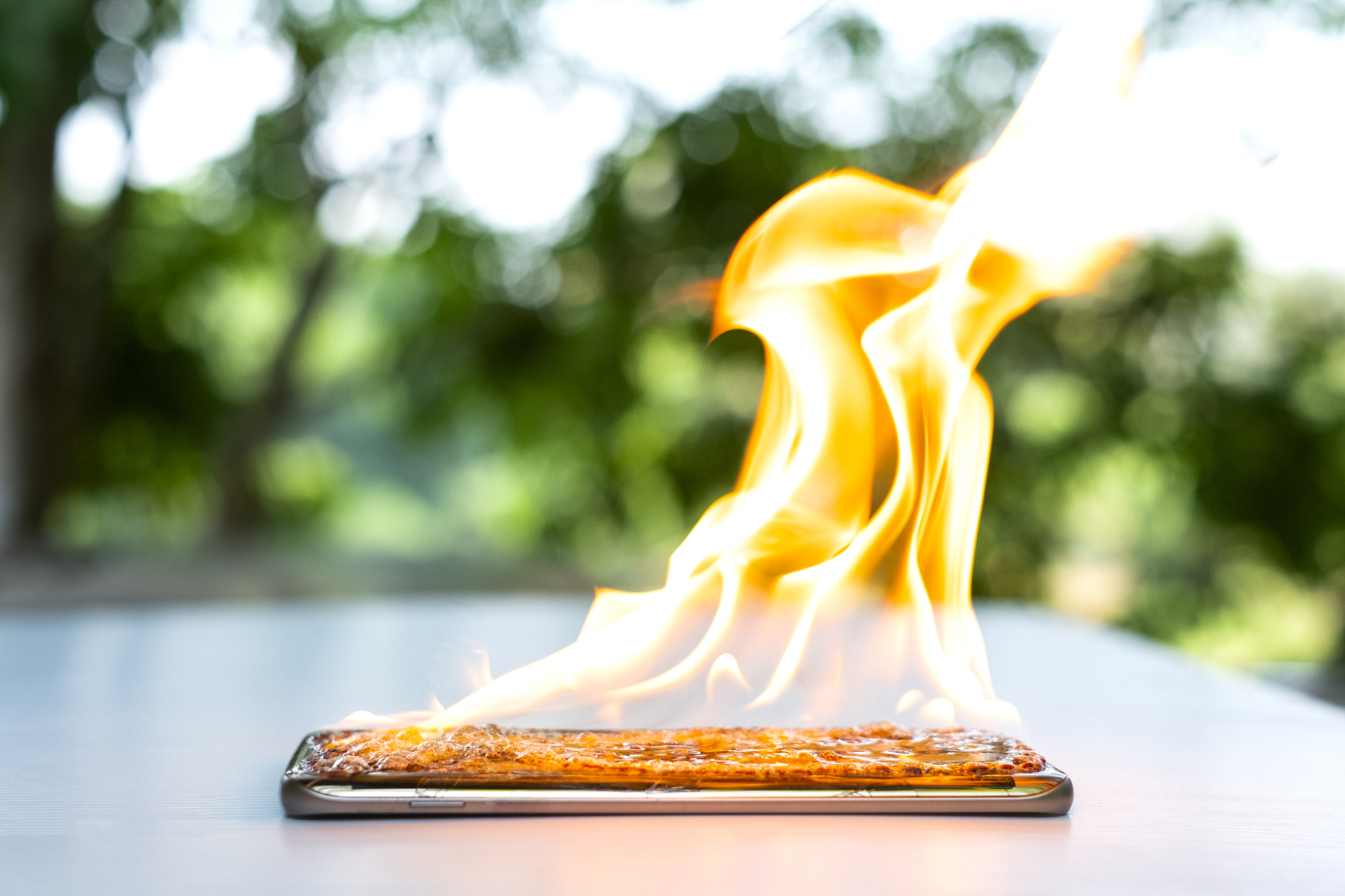 Smartphone noir sur tableau blanc allumé en feu.