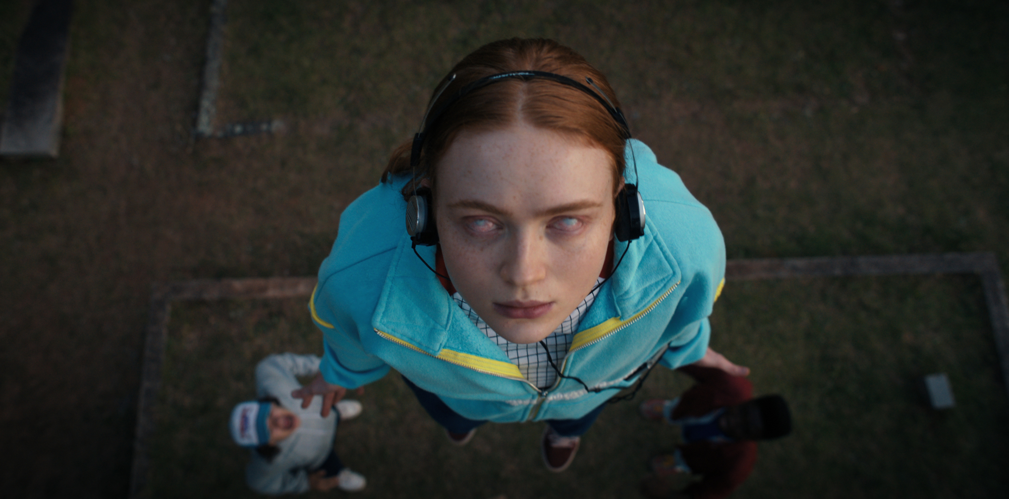 Une fille portant des écouteurs lévite dans les airs, les yeux révulsés dans la tête.