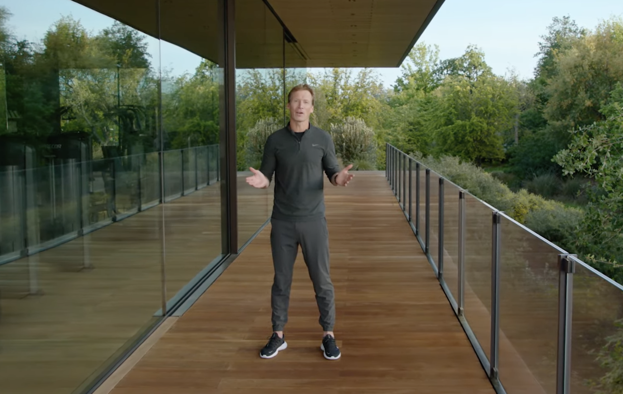 Craig Bolton se tient sur un balcon dans un survêtement et des chaussures Nike gris sidéral.