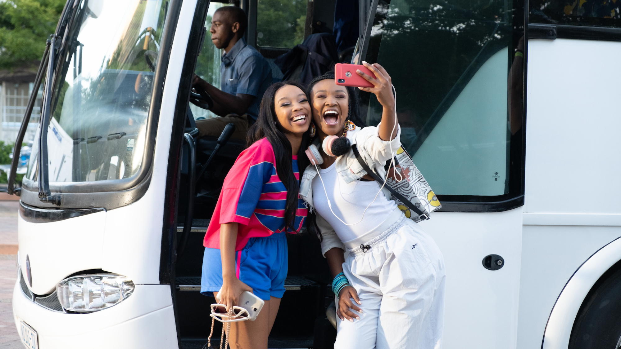 Deux femmes posent pour un selfie devant un coach.