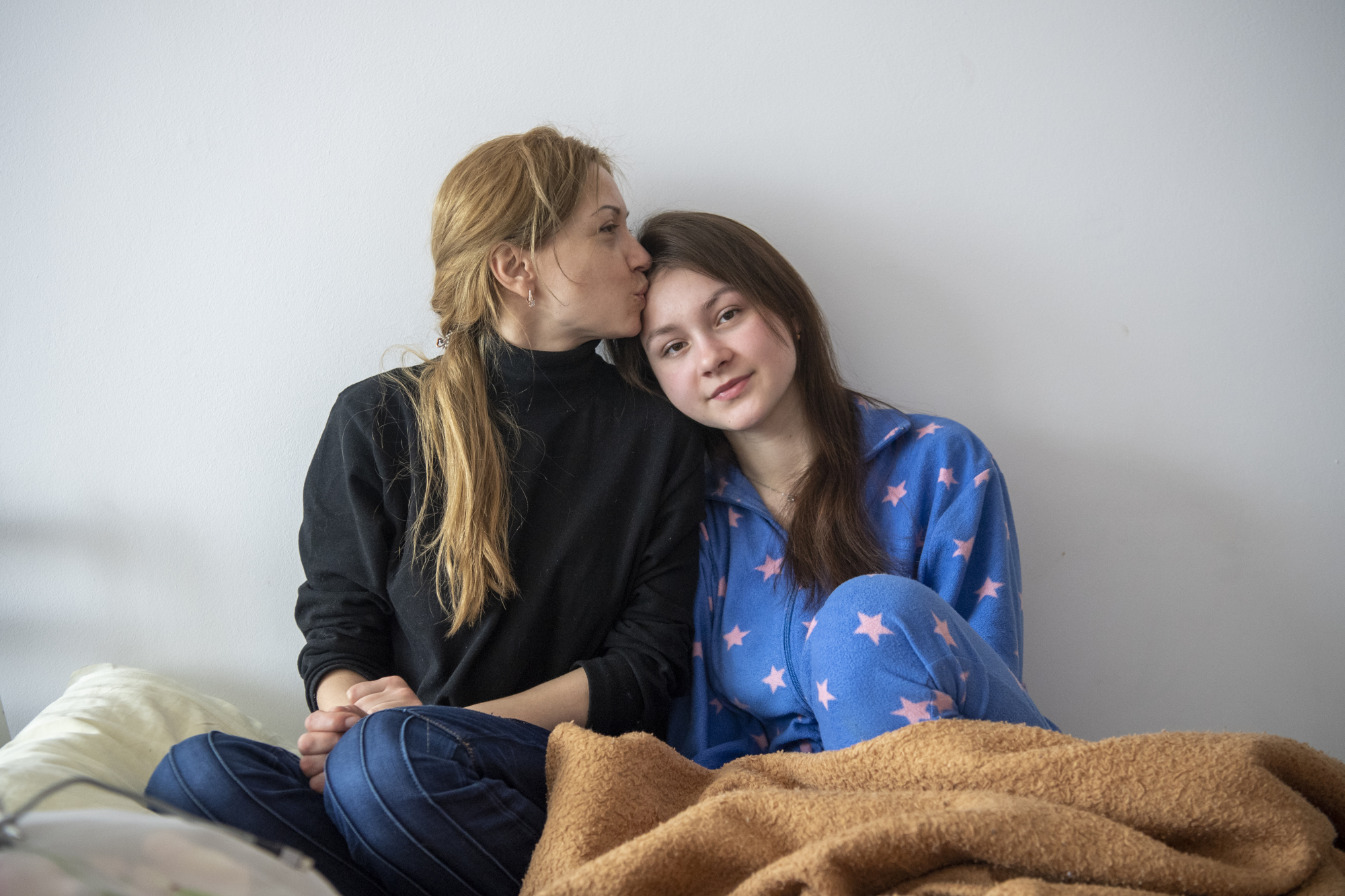 Une femme embrasse une femme plus jeune sur le front.