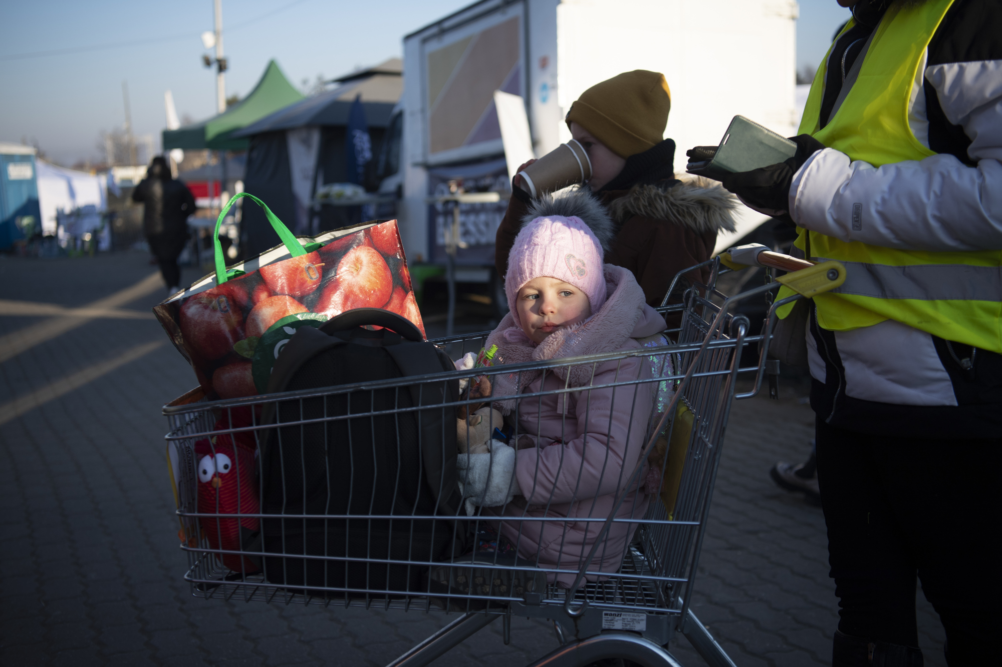 Deux enfants sont assis dans un caddie.