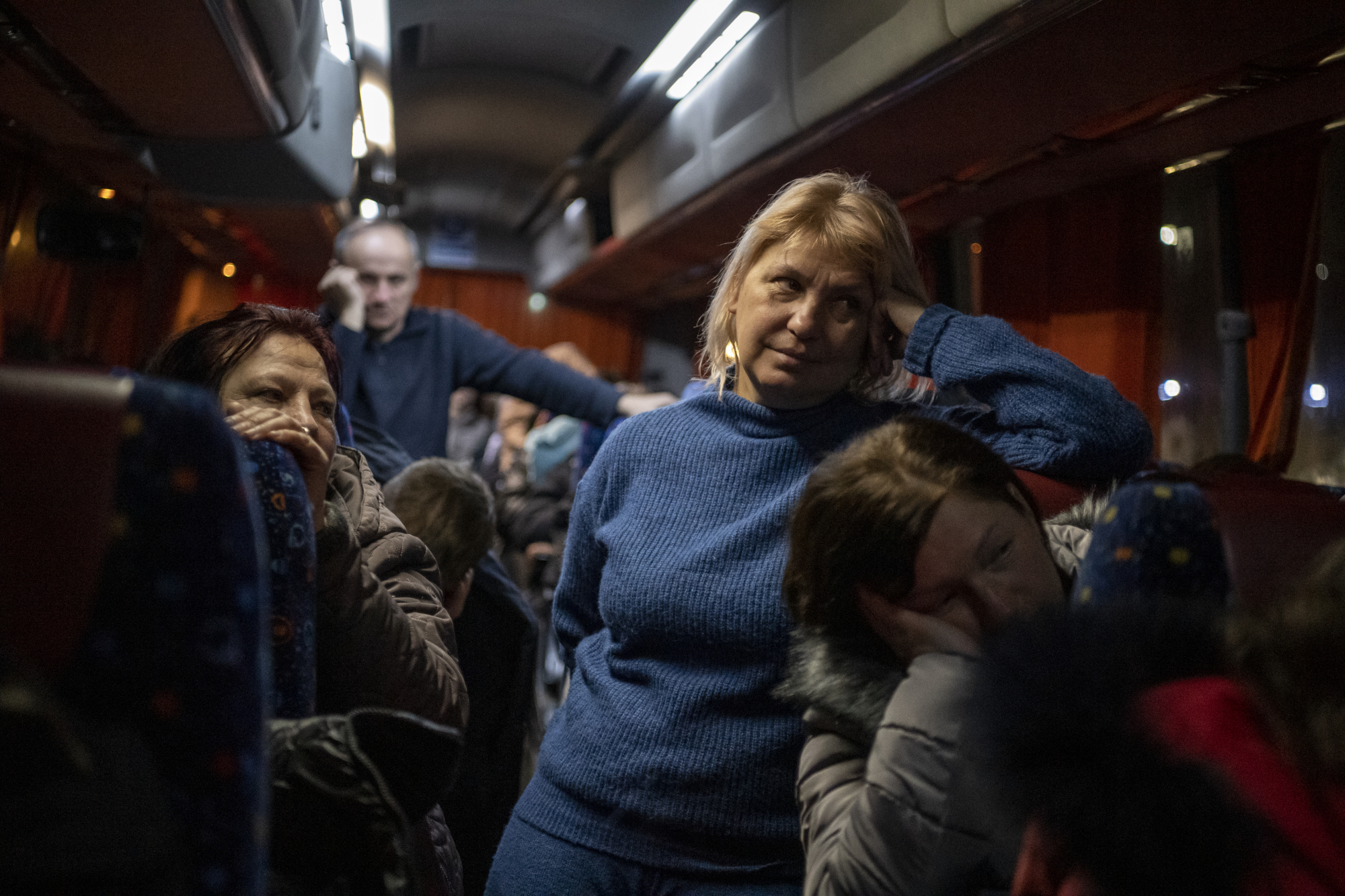 Une femme regarde une caméra dans un bus.