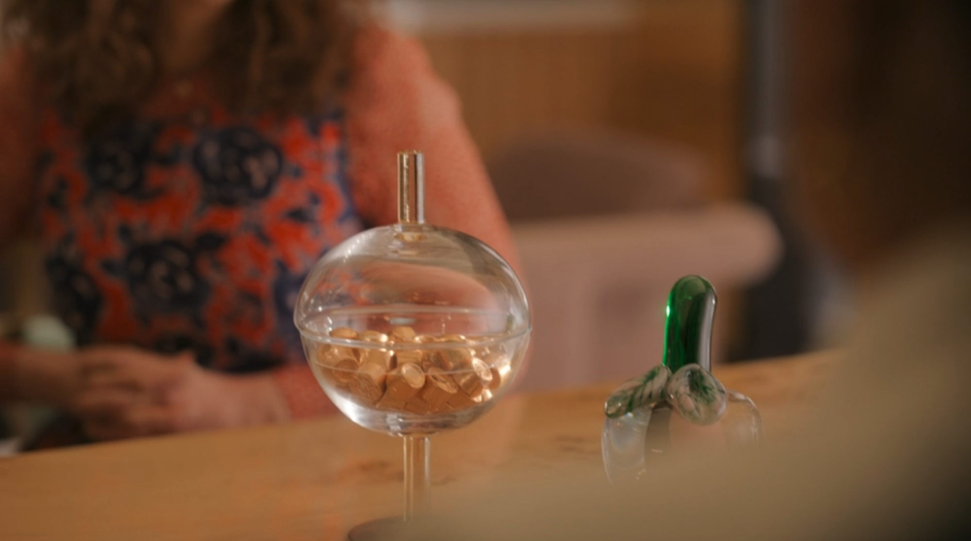 Un bocal en verre sur un bureau rempli de Rolos.