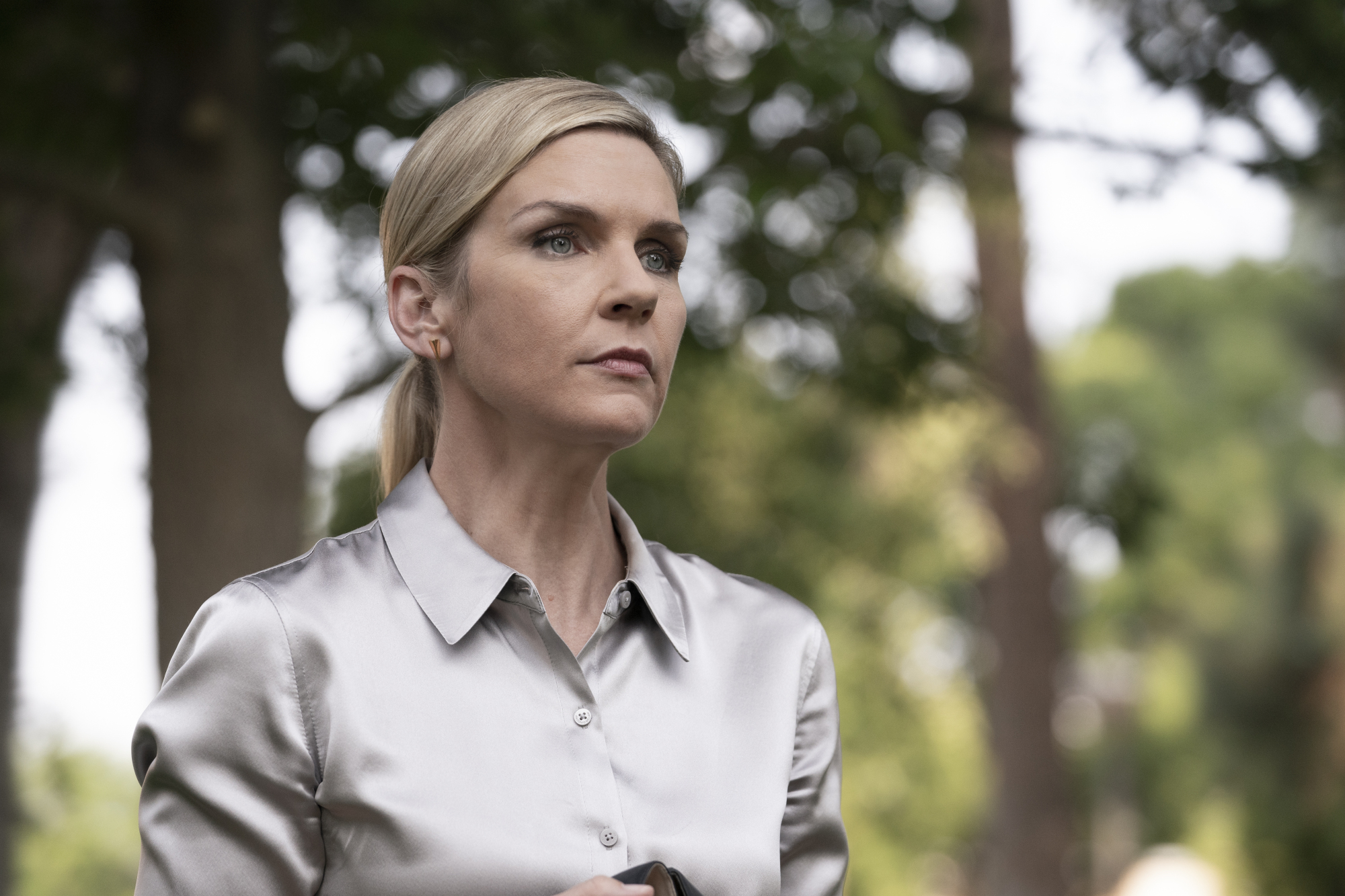 Une femme (Rhea Seehorn dans le rôle de Kim Wexler) debout à l'extérieur.