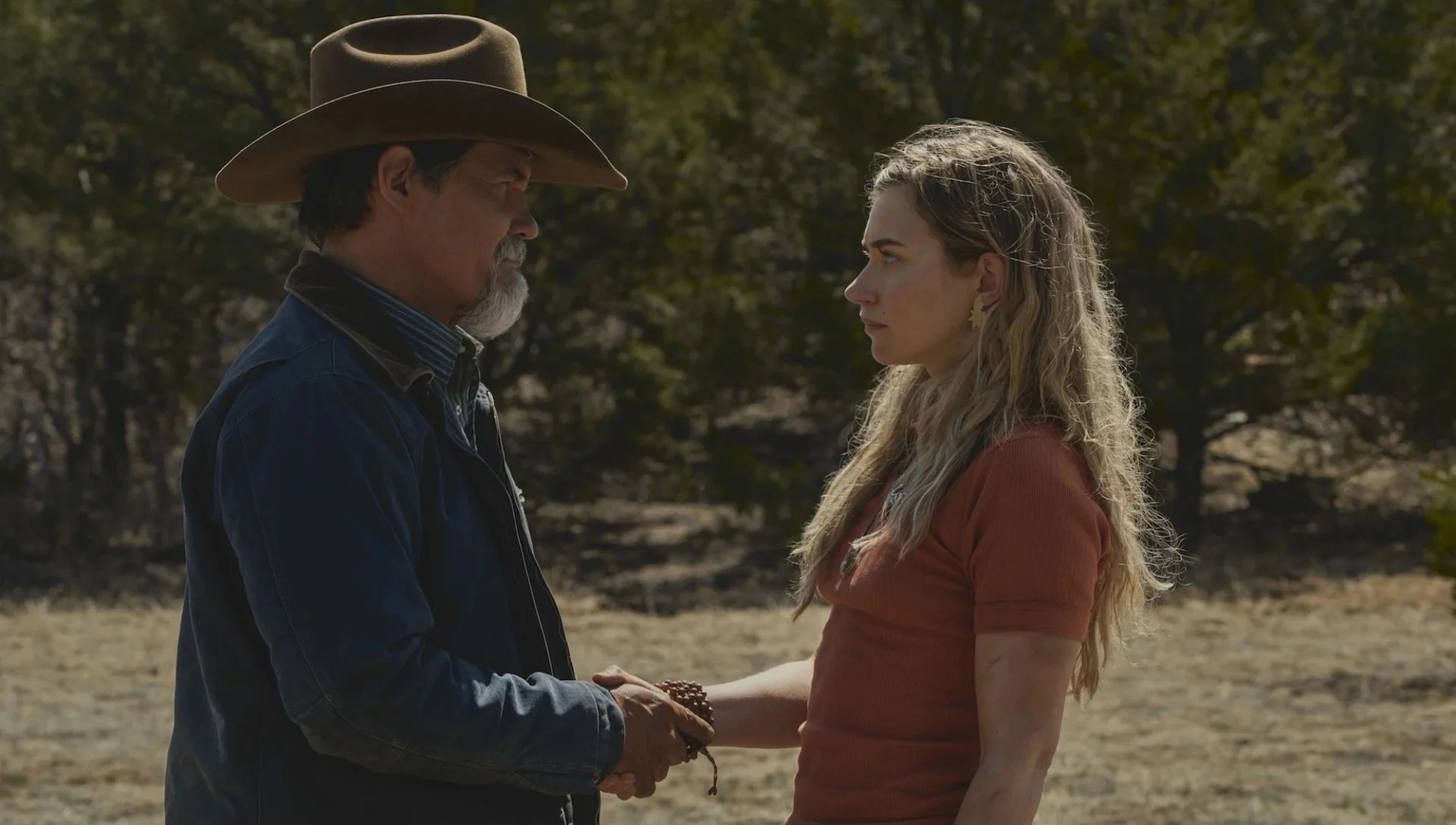 Un homme avec un chapeau de cow-boy et une femme se serrant la main.