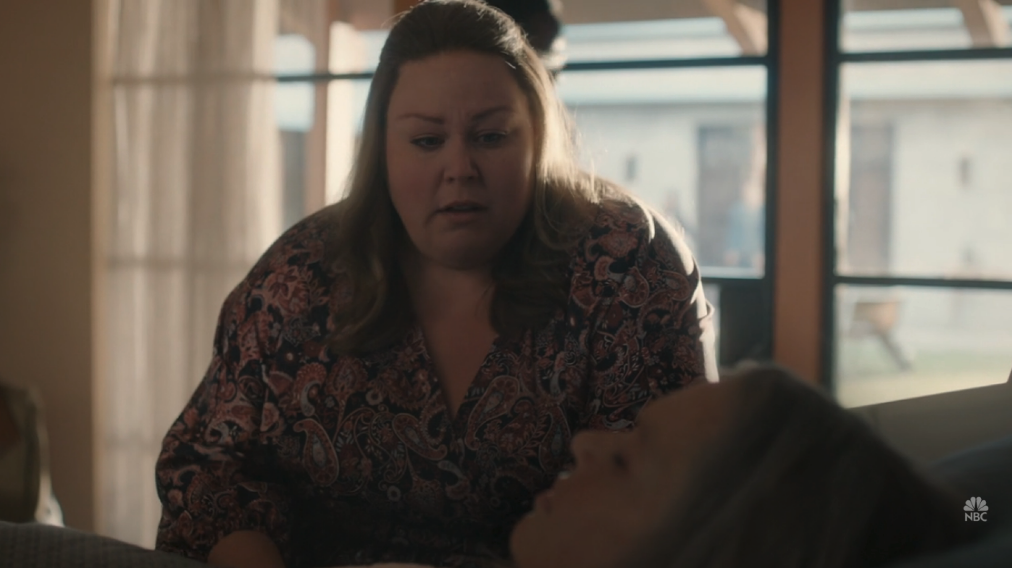 Une femme (Chrissy Metz) debout au-dessus d'une autre femme (Mandy Moore) qui est au lit.