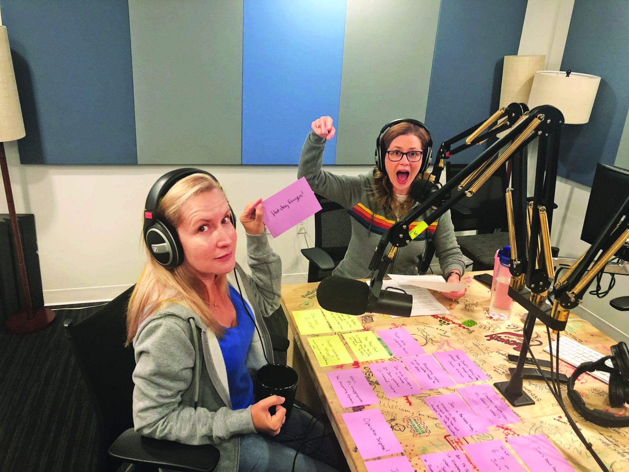 Deux femmes (Jenna Fischer et Angela Kinsey) assises dans un studio d'enregistrement devant des micros.