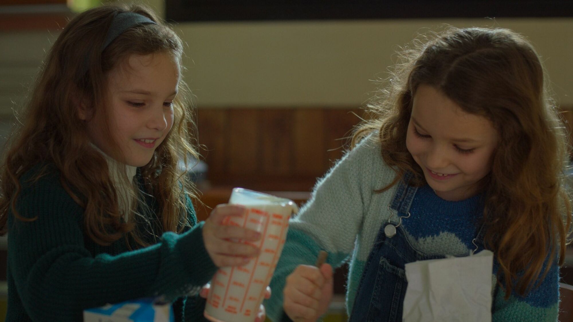 Deux filles font des crêpes. 