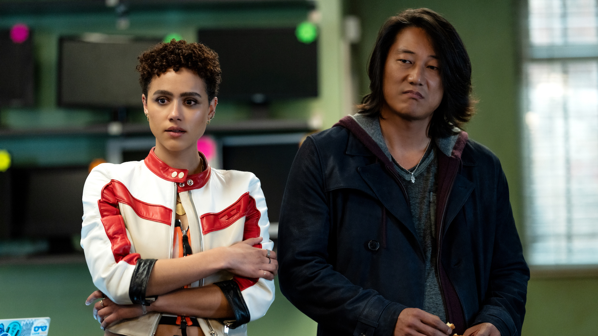 Nathalie Emmanuel et Sung Kang se tiennent côte à côte dans une salle high-tech dans le film 