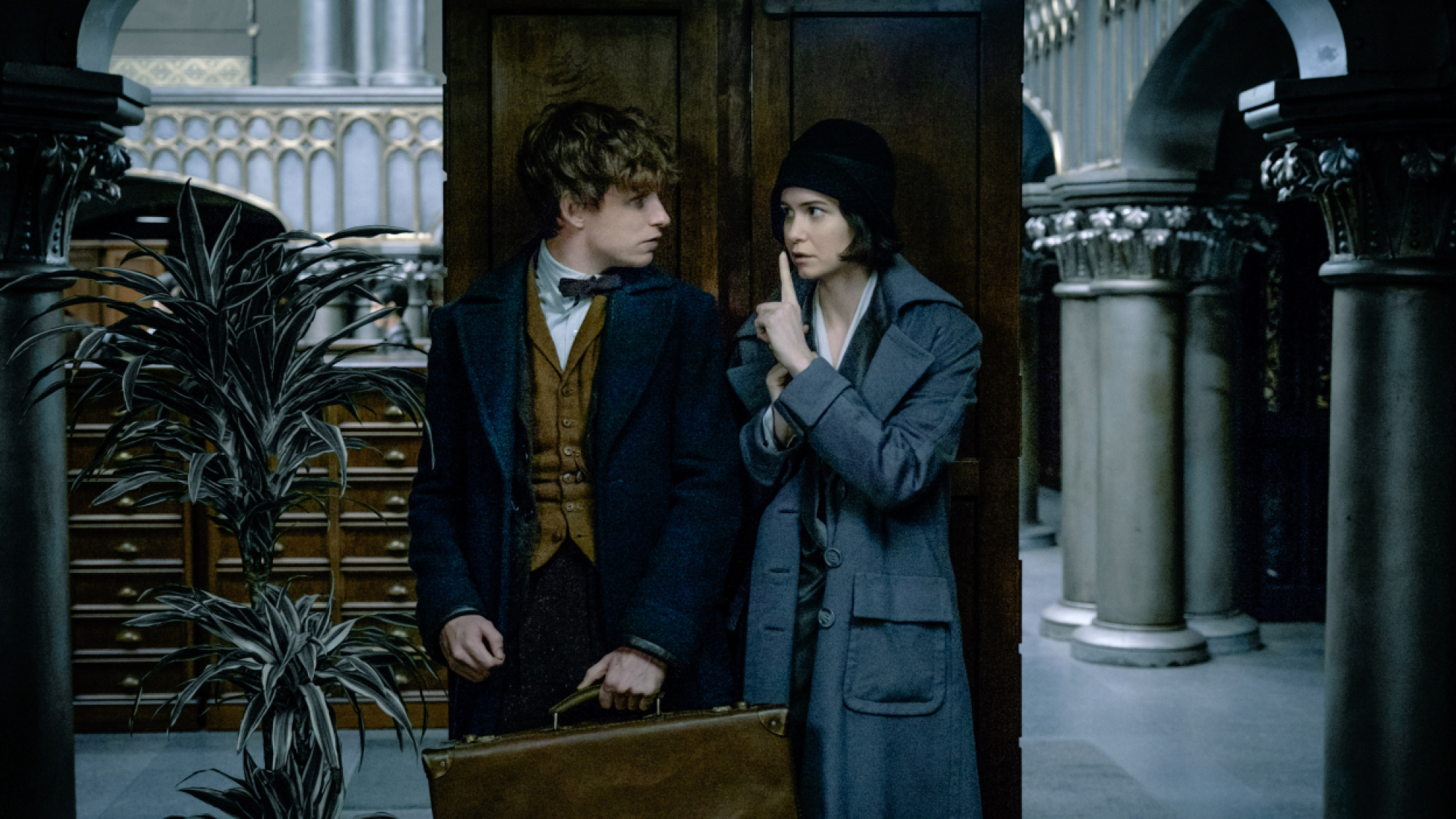 Eddie Redmayne dans le rôle de Newt Scamander se fait taire par Katherine Waterston dans le rôle de Tina Goldstein.