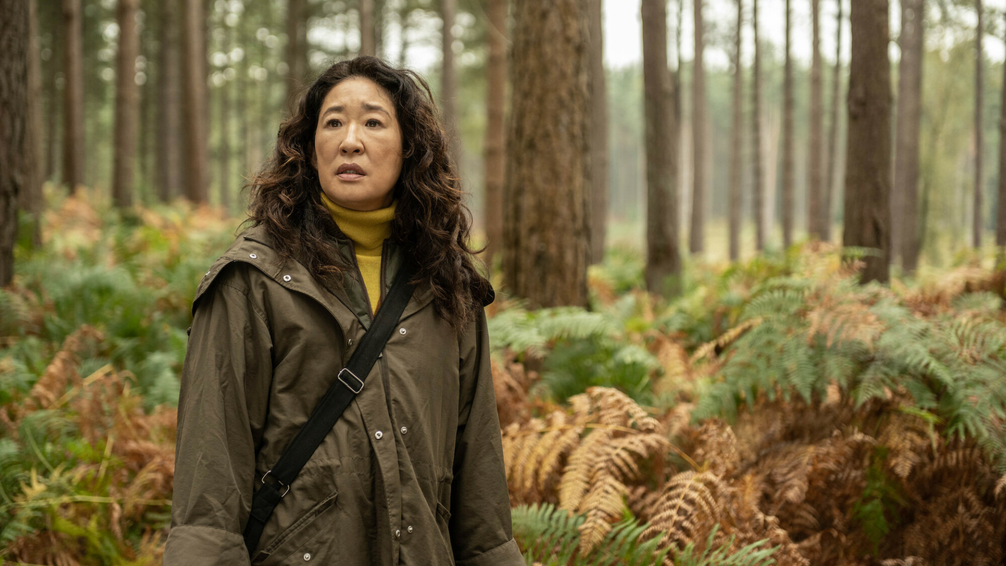 Sandra Oh se tient au milieu d'une forêt.