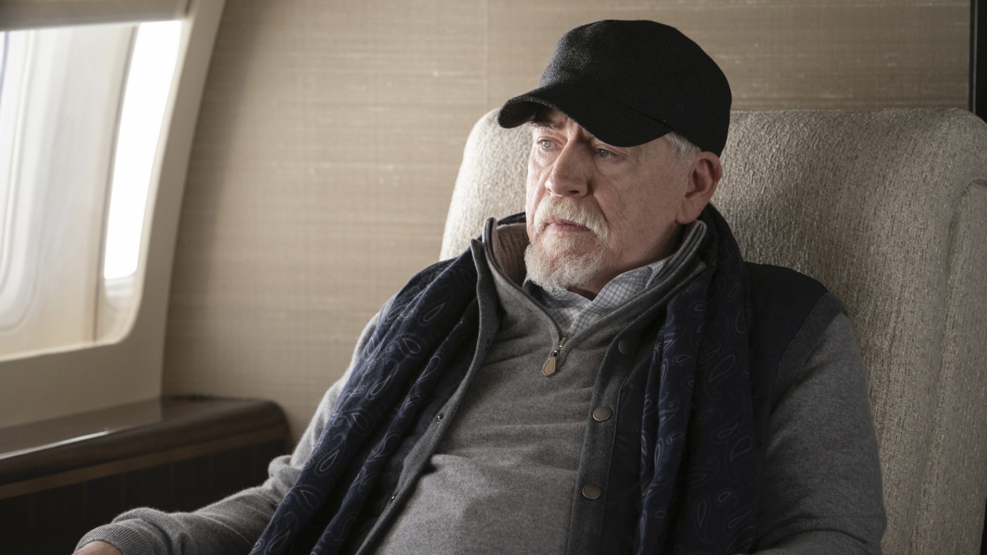 Un vieil homme avec une casquette de baseball dans un jet privé.