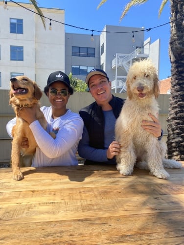 Deux membres du parc posent avec leurs chiens, une récupération d'or et un labradoodle.