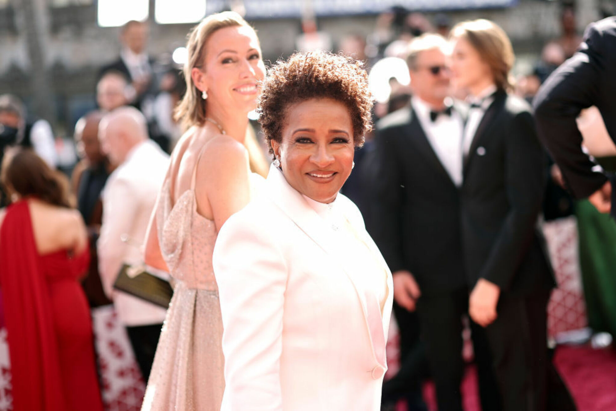 Wanda Sykes sourit dans un costume blanc. 