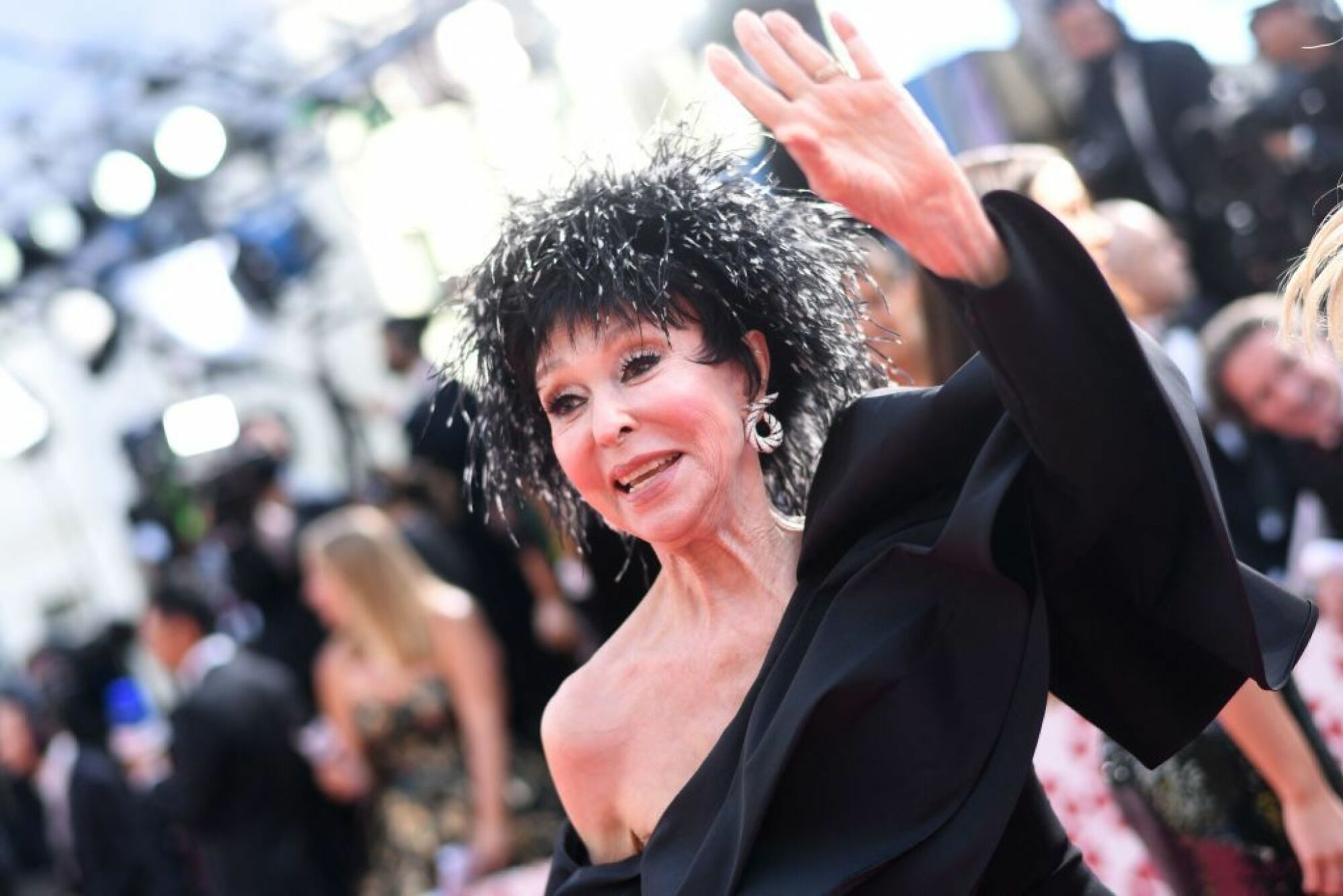 Rita Moreno ondule dans une robe noire à épaules dénudées. 