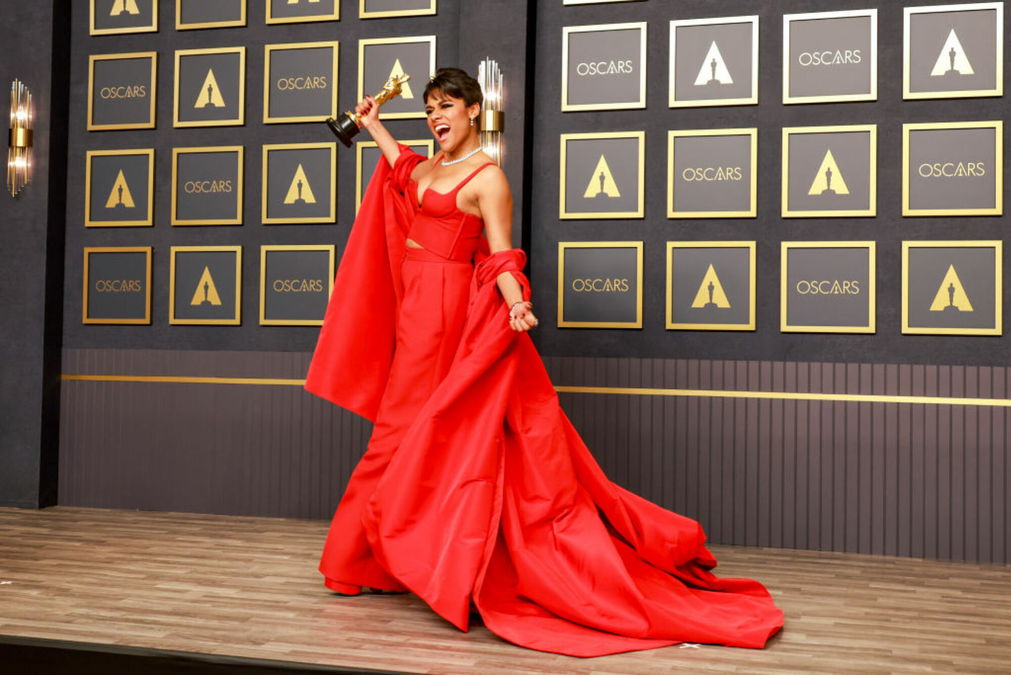 Ariana DeBose en robe rouge tenant un Oscar.