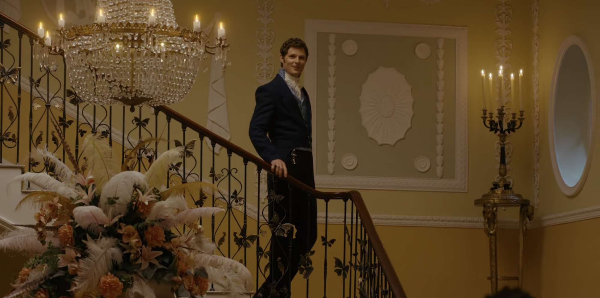 Un homme en costume de l'époque Regency descendant un escalier. 