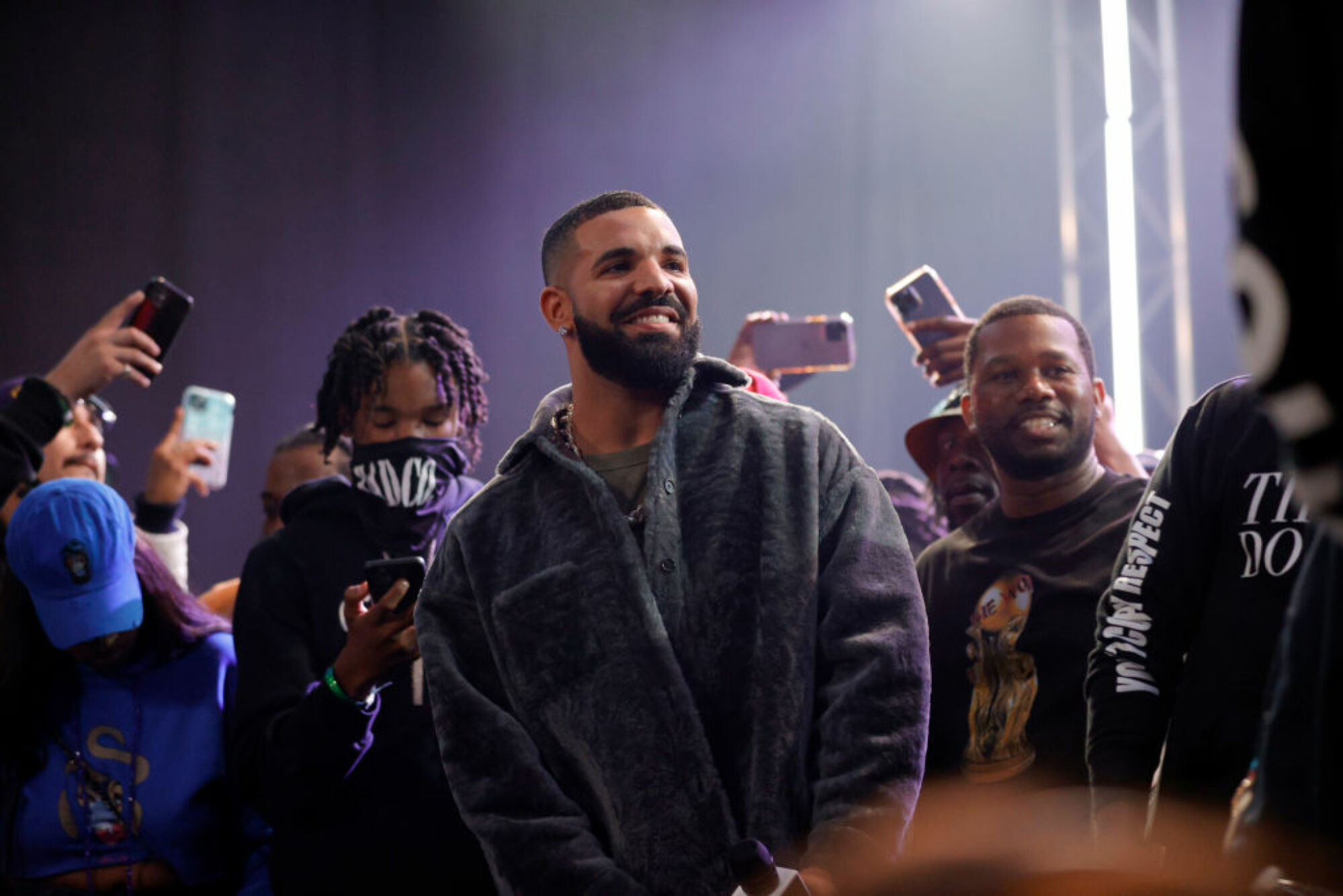 Drake, souriant, entouré de fans